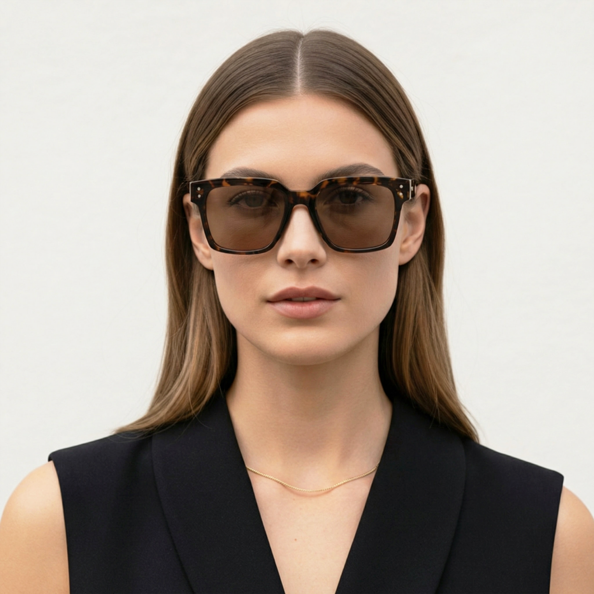 Woman wearing a pair of sunglasses with a plain background