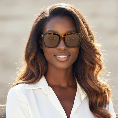 Woman wearing sunglasses and a white shirt with a blurred background